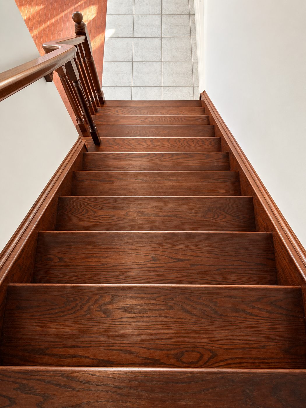 Refinished hardwood staircase with a stained finish, a wood handrail and turned spindles